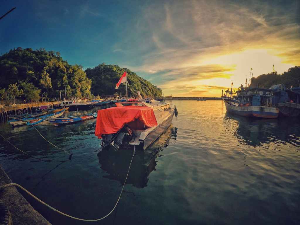motor boat near dock during sunset