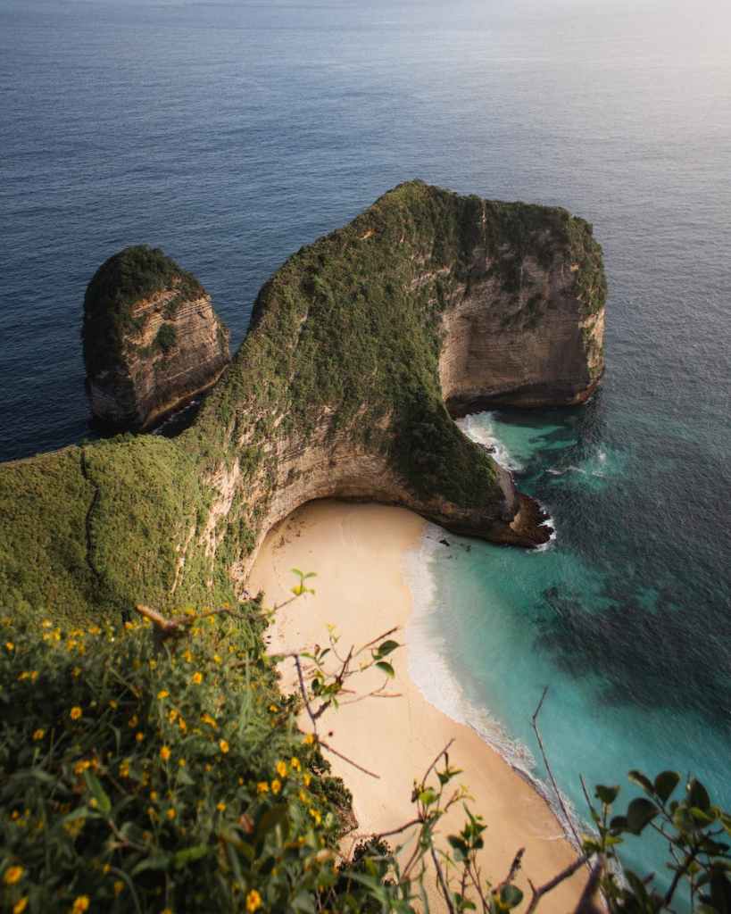 green and brown rock formation on seashore